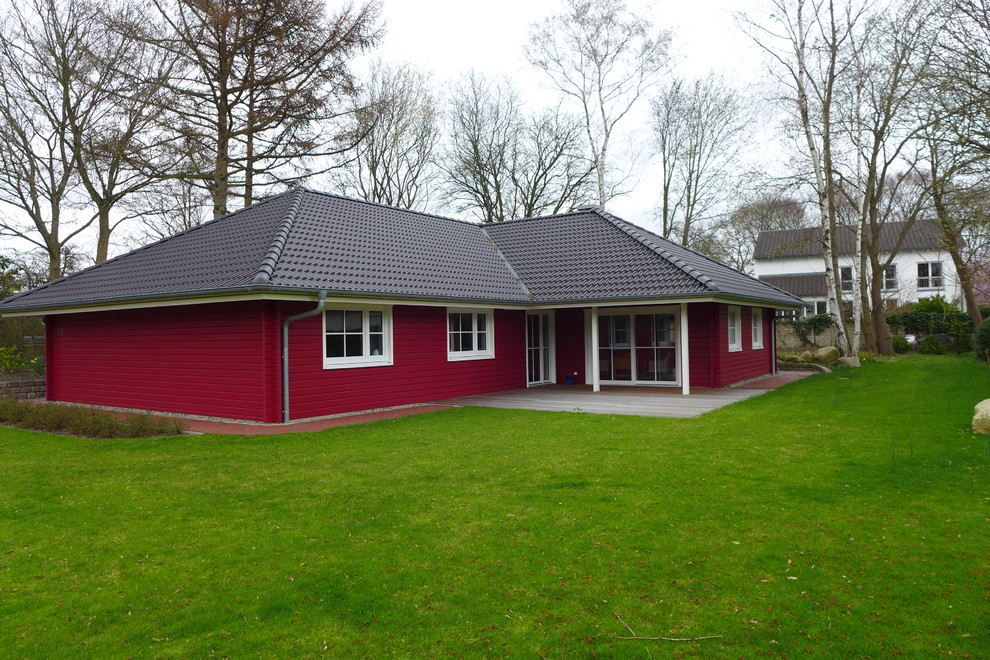 Diseño de fachada de casa roja costera de tamaño medio de una planta con revestimiento de madera, tejado a cuatro aguas y tejado de teja de barro