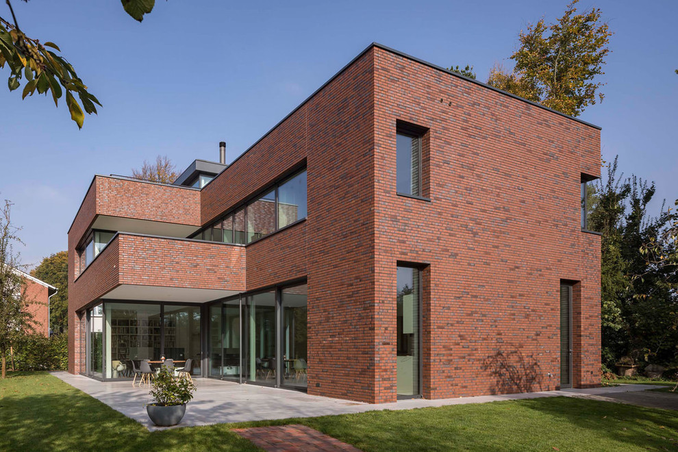 Idee per la villa grande rossa moderna a due piani con rivestimento in mattoni e tetto piano