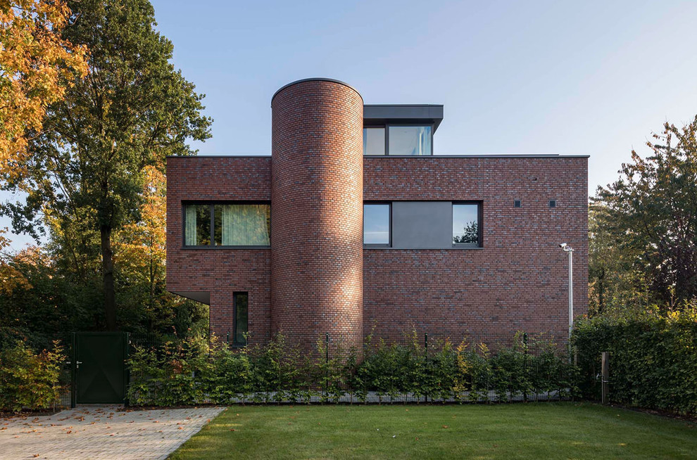 Modelo de fachada de casa roja minimalista grande de dos plantas con revestimiento de ladrillo y tejado plano
