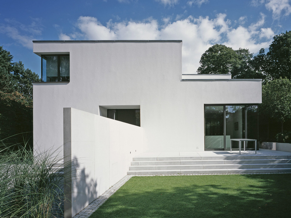 Photo of a medium sized and white modern two floor house exterior in Hamburg with a flat roof.