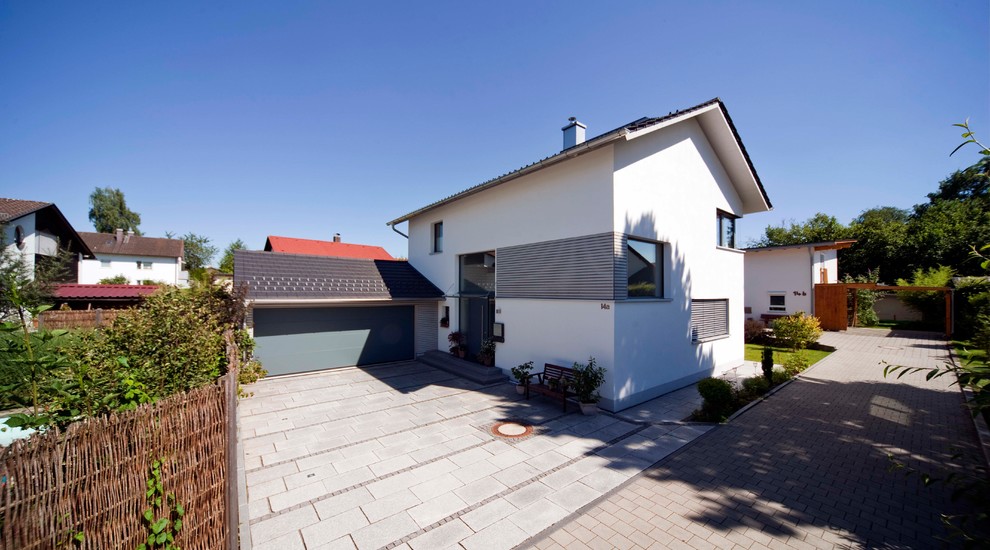 Kleines, Zweistöckiges Modernes Einfamilienhaus mit Mix-Fassade, weißer Fassadenfarbe, Satteldach, Ziegeldach und grauem Dach in München