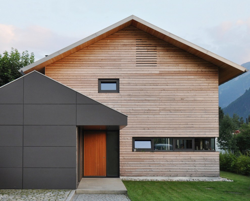 Brown and medium sized scandi two floor house exterior in Munich with wood cladding and a pitched roof.