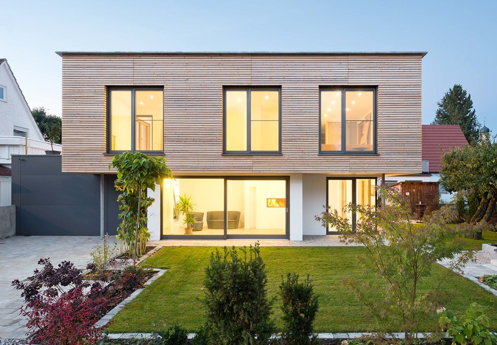 Idée de décoration pour une façade de maison beige minimaliste en bois à un étage et de taille moyenne avec un toit plat.