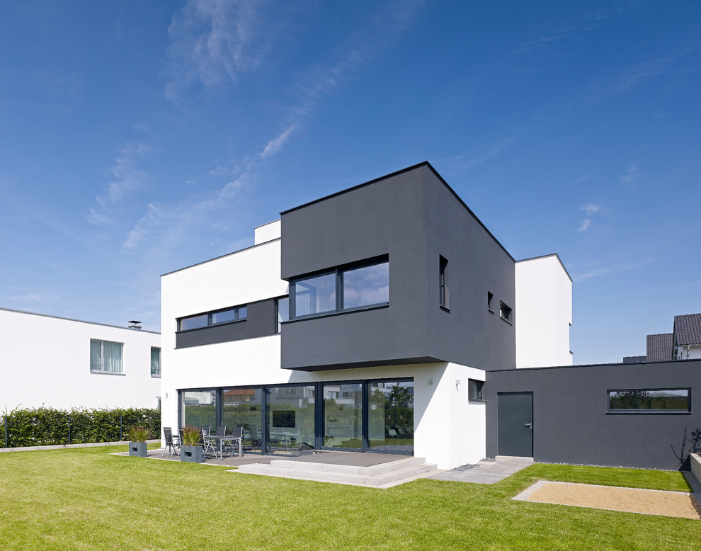 Inspiration for a large and black two floor house exterior in Cologne with a flat roof.