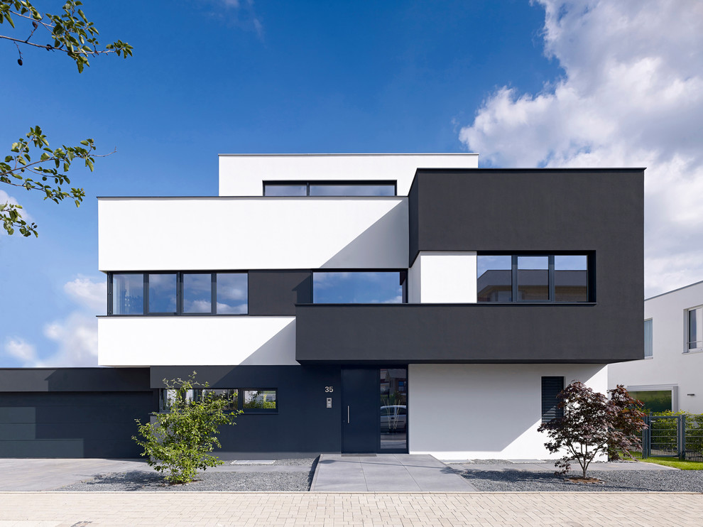 Inspiration for a large and black contemporary house exterior in Cologne with three floors and a flat roof.