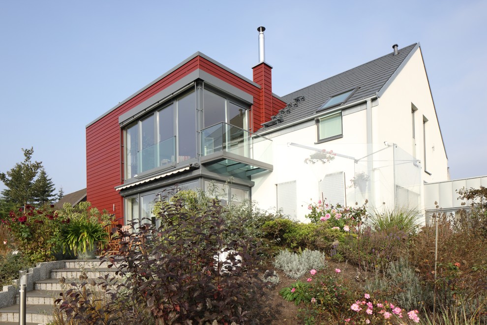 Стильный дизайн: двухэтажный, красный частный загородный дом среднего размера в современном стиле с облицовкой из ЦСП - последний тренд