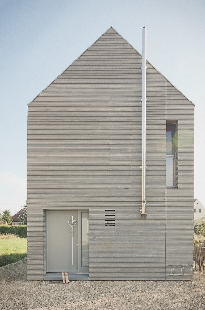 Пример оригинального дизайна: двухэтажный, деревянный, серый дом в современном стиле с двускатной крышей