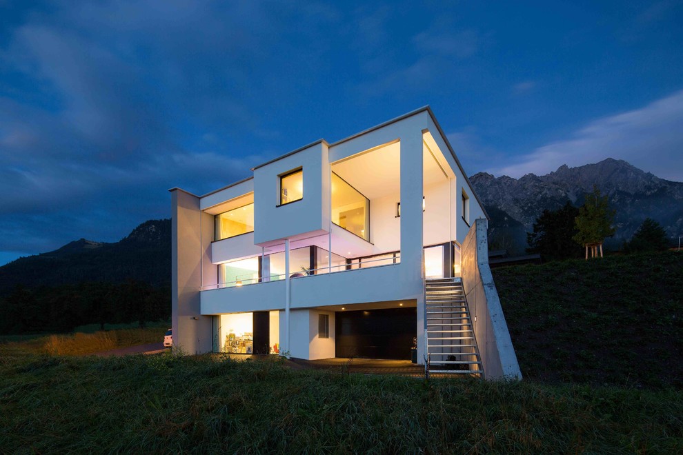 На фото: трехэтажный, белый дом в современном стиле с плоской крышей с