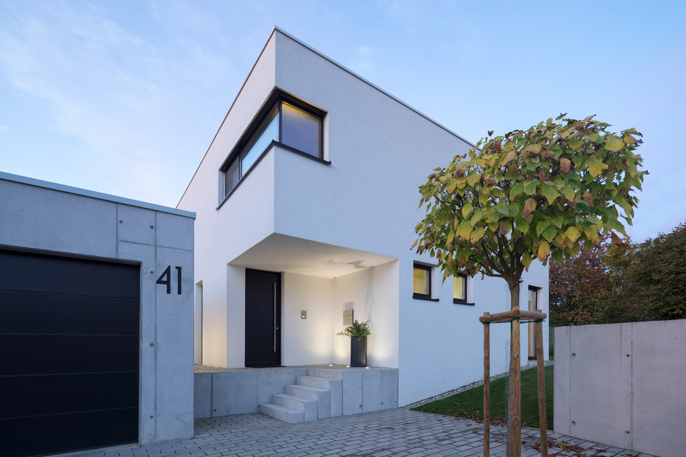This is an example of a white modern two floor house exterior in Stuttgart with a flat roof.