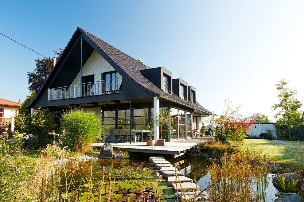 Inspiration for a white traditional two floor glass detached house in Stuttgart with a pitched roof and a tiled roof.