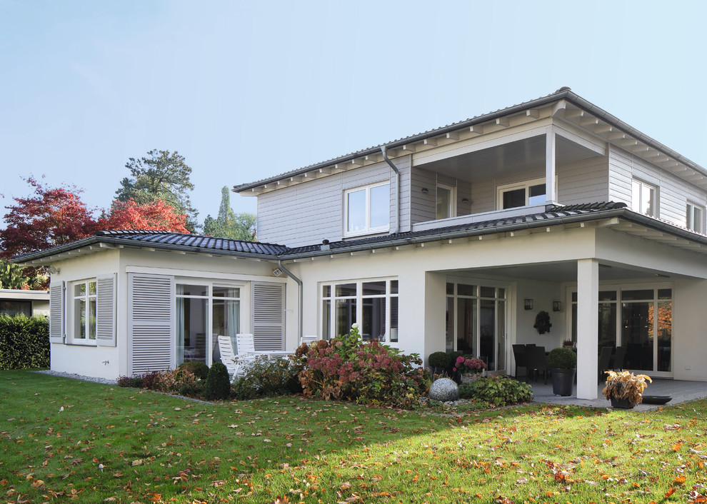 На фото: двухэтажный, белый частный загородный дом среднего размера в современном стиле с плоской крышей и облицовкой из ЦСП с