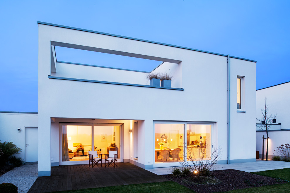 Ejemplo de fachada blanca minimalista de tamaño medio de dos plantas con tejado plano