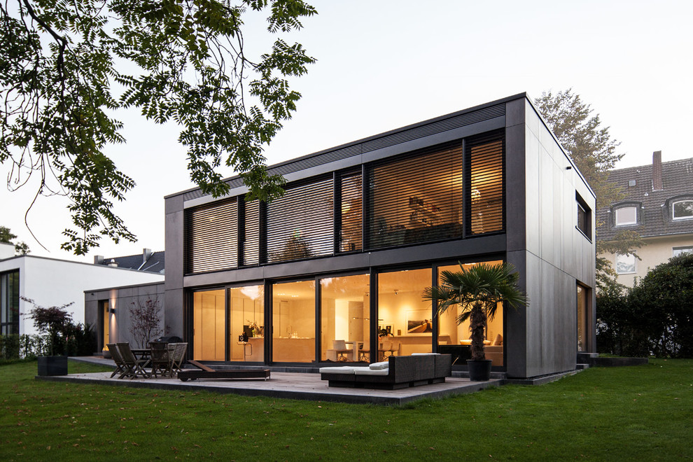 Идея дизайна: маленький, двухэтажный, серый частный загородный дом в современном стиле с облицовкой из бетона и плоской крышей для на участке и в саду