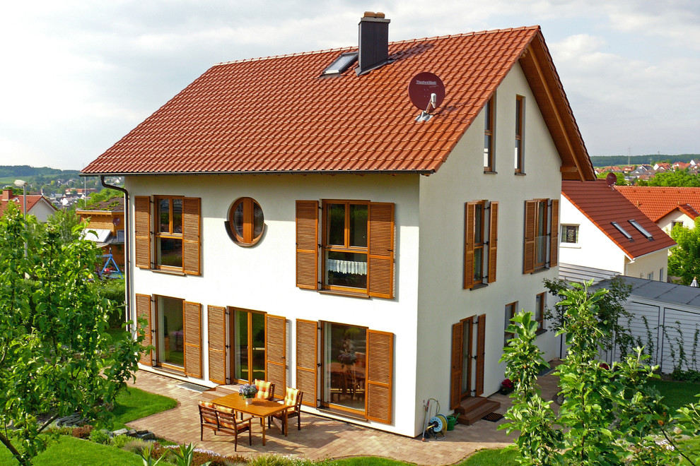 Idée de décoration pour une façade de maison blanche champêtre en adobe de taille moyenne et à un étage avec un toit à deux pans et un toit en tuile.