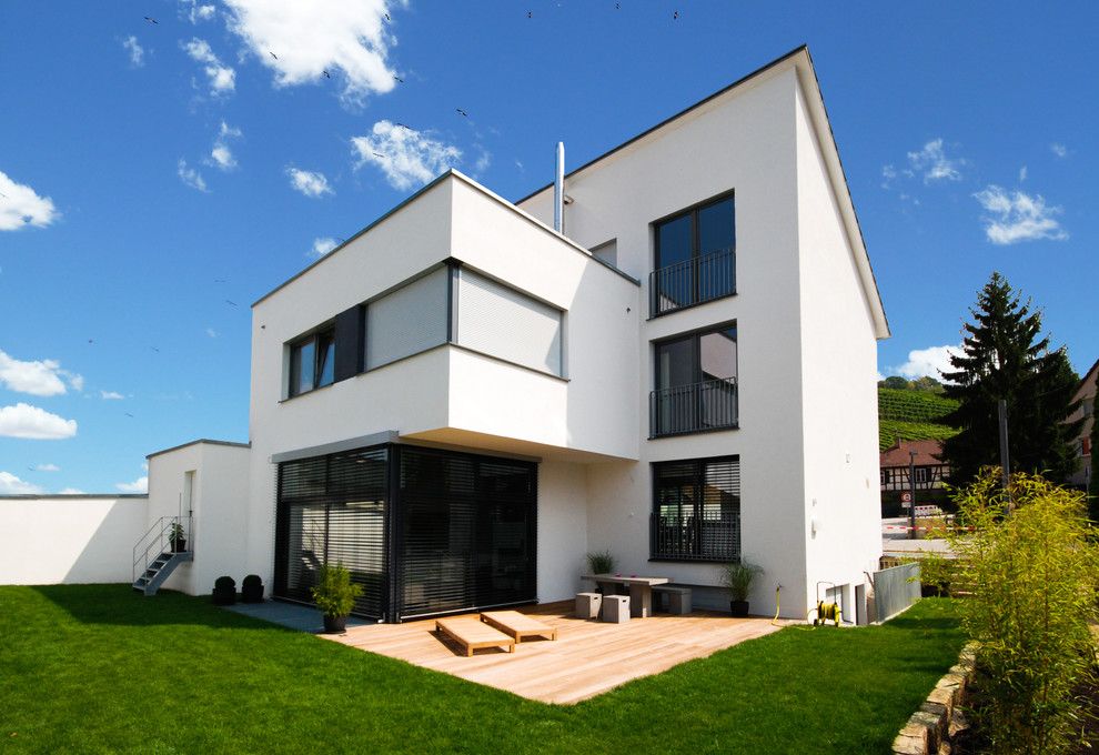 Design ideas for a medium sized and white contemporary house exterior in Stuttgart with three floors and a lean-to roof.