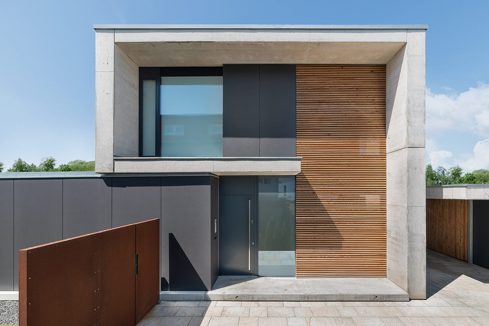 Inspiration for a brown contemporary two floor concrete house exterior in Nuremberg with a flat roof.