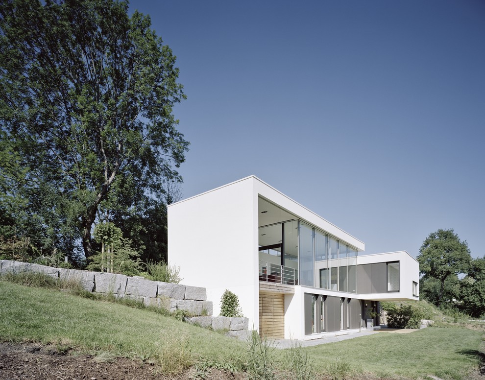 Diseño de fachada blanca actual de tamaño medio de dos plantas con tejado plano