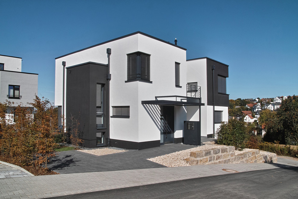 Photo of a white contemporary two floor house exterior in Frankfurt with a flat roof.