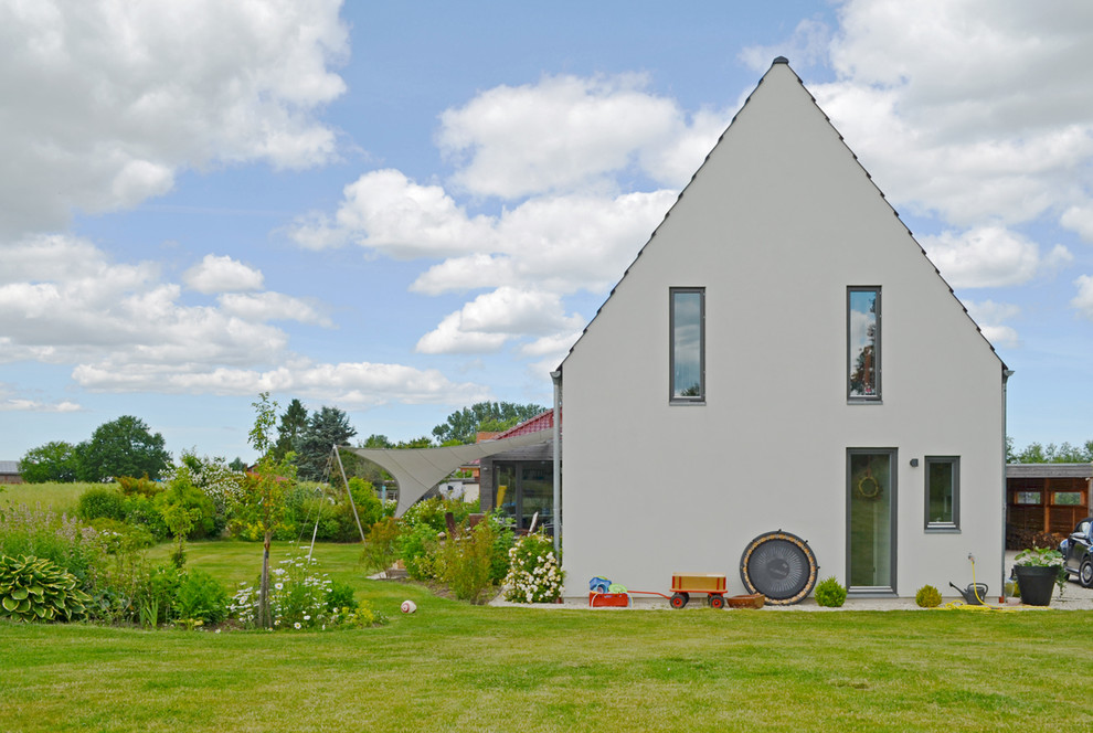 Diseño de fachada beige escandinava de tamaño medio de dos plantas con tejado a dos aguas