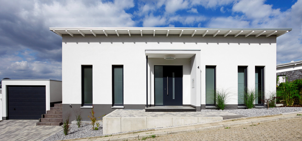 Foto de fachada blanca contemporánea de tamaño medio a niveles con tejado de un solo tendido y revestimiento de estuco