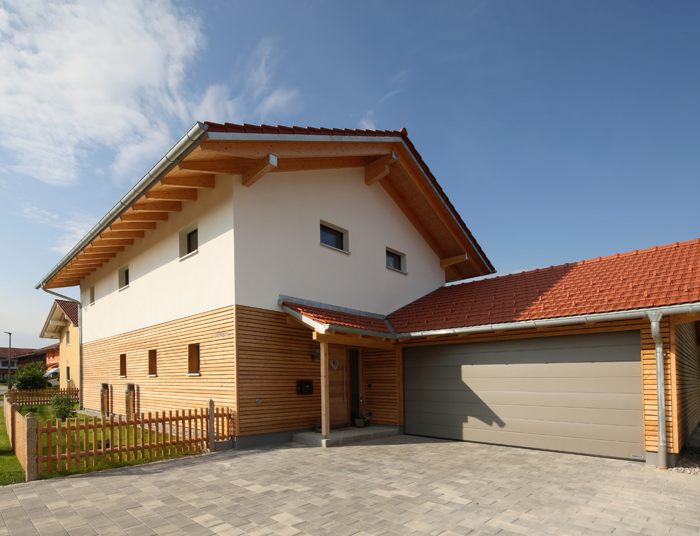 Mittelgroßes, Einstöckiges Klassisches Einfamilienhaus mit Mix-Fassade, weißer Fassadenfarbe, Satteldach und Ziegeldach in München