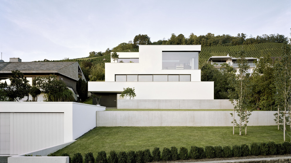 Large and white contemporary render house exterior in Stuttgart with three floors and a flat roof.