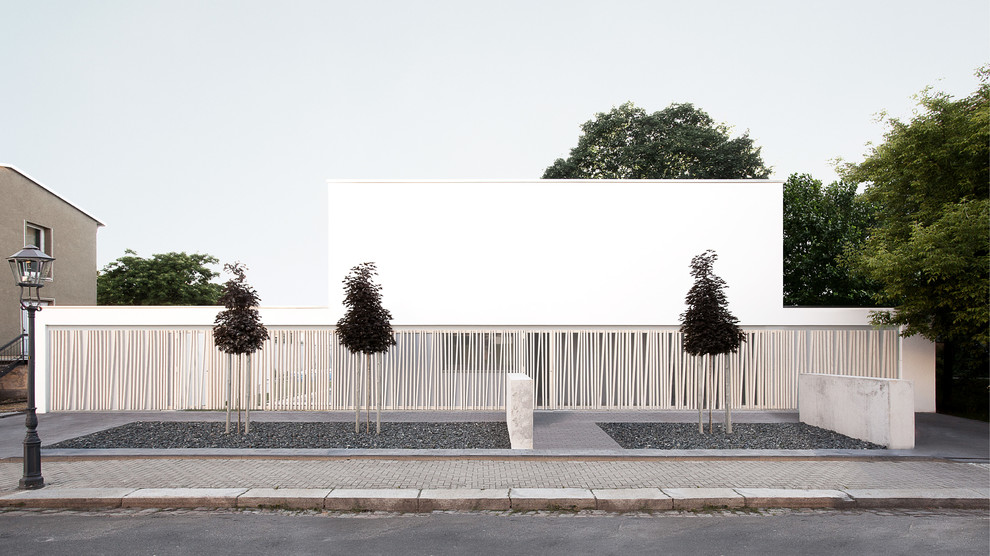 Esempio della facciata di una casa grande bianca contemporanea con rivestimento con lastre in cemento e tetto piano