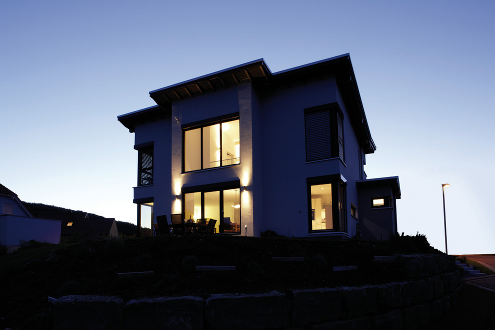 Свежая идея для дизайна: двухэтажный, белый частный загородный дом в современном стиле с облицовкой из цементной штукатурки - отличное фото интерьера