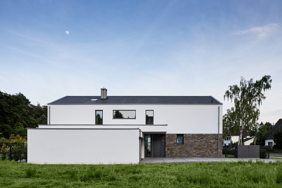 Zweistöckiges, Großes Landhaus Einfamilienhaus mit weißer Fassadenfarbe, Satteldach, Ziegeldach und Mix-Fassade in Köln