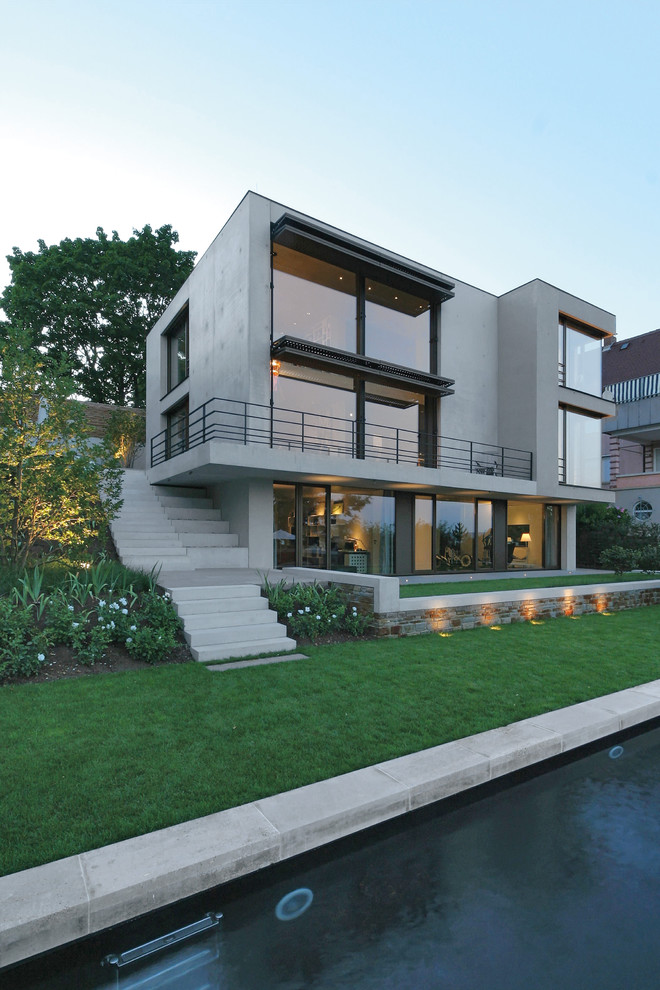Идея дизайна: трехэтажный, серый дом среднего размера в стиле модернизм с облицовкой из бетона и плоской крышей