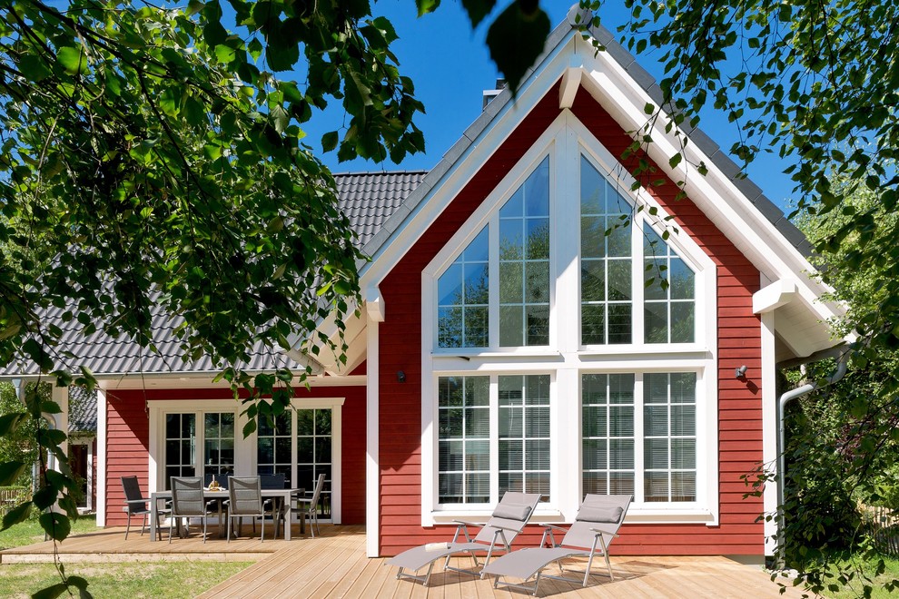 Réalisation d'une petite façade de maison rouge nordique en bois de plain-pied avec un toit à deux pans et un toit en tuile.