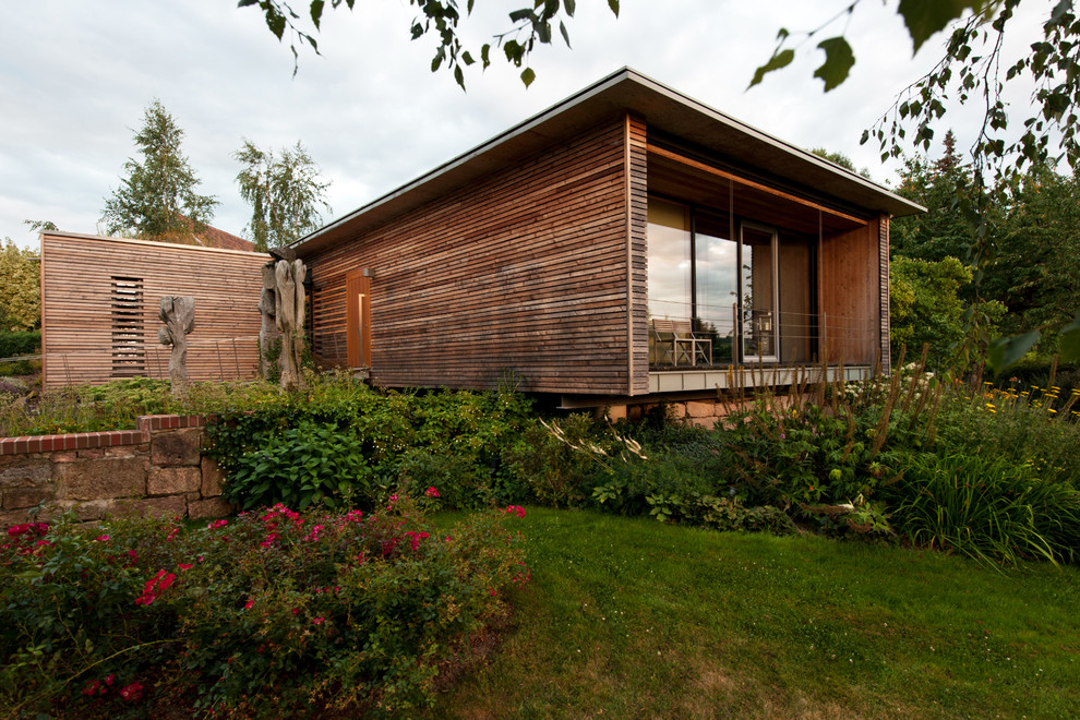 Idée de décoration pour une façade de maison marron design en bois de taille moyenne et de plain-pied avec un toit plat.