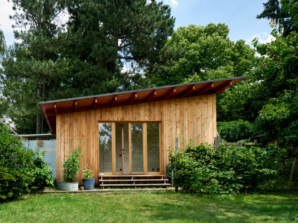 Cette image montre une petite façade de Tiny House beige minimaliste en bois de plain-pied avec un toit plat et un toit mixte.