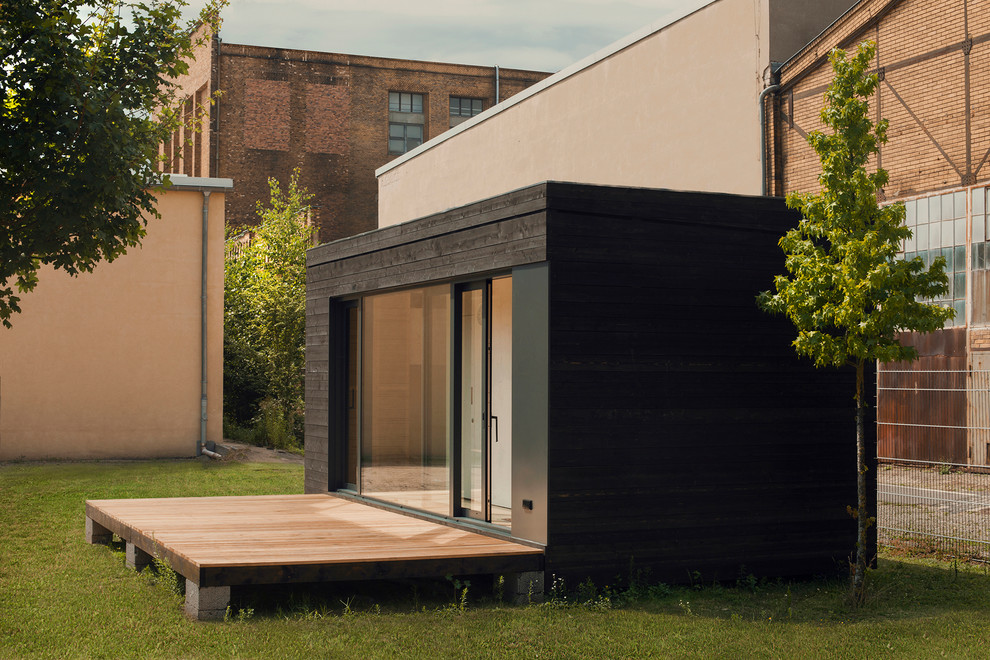 Пример оригинального дизайна: маленький, одноэтажный, деревянный, черный дом в современном стиле с плоской крышей для на участке и в саду