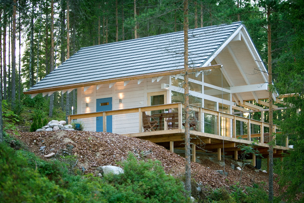 Immagine della facciata di una casa piccola bianca contemporanea a un piano con rivestimento in legno e tetto a capanna