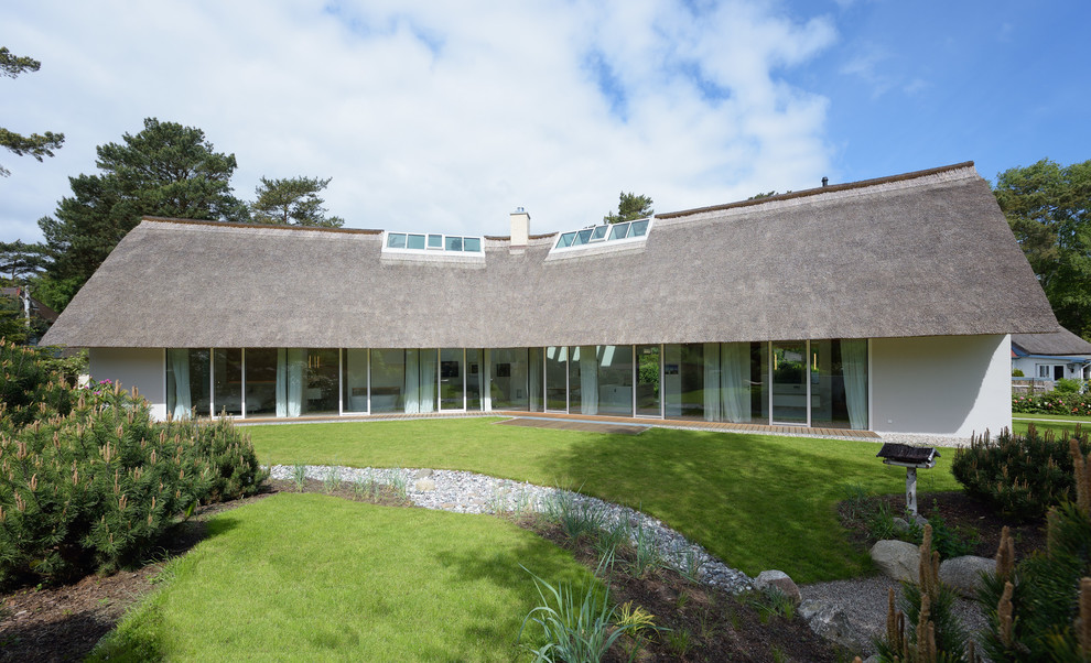 Inspiration for a white contemporary bungalow house exterior in Berlin with a pitched roof.