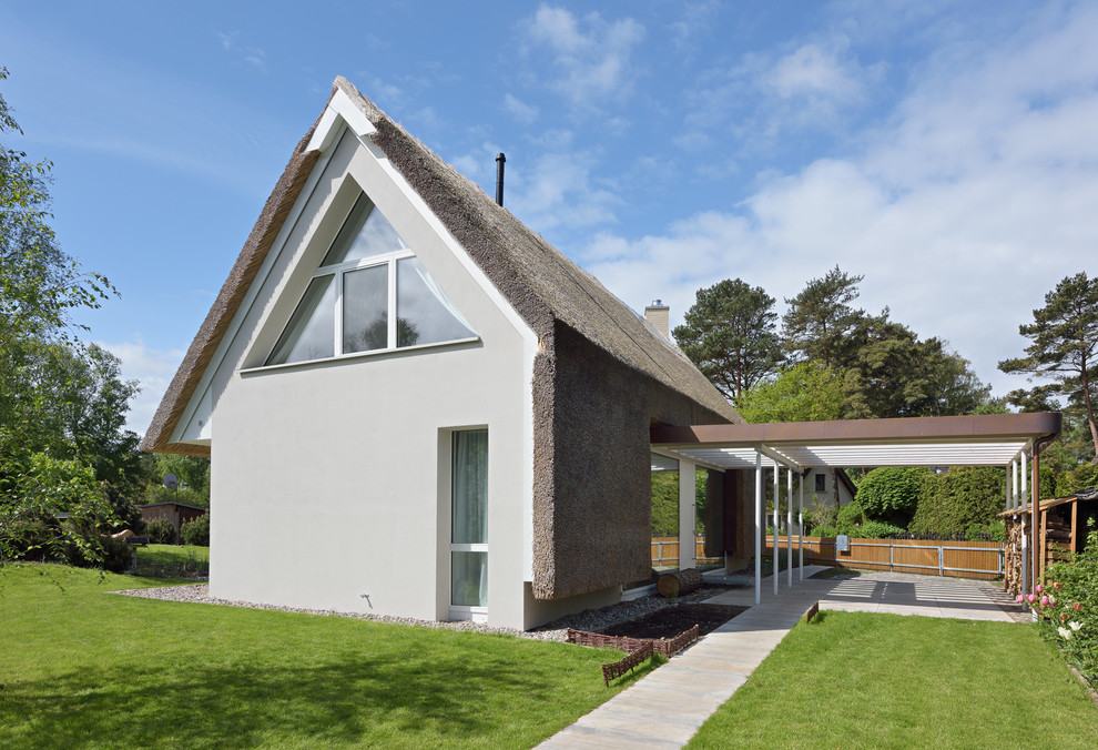 Foto della facciata di una casa piccola bianca contemporanea a due piani con tetto a capanna