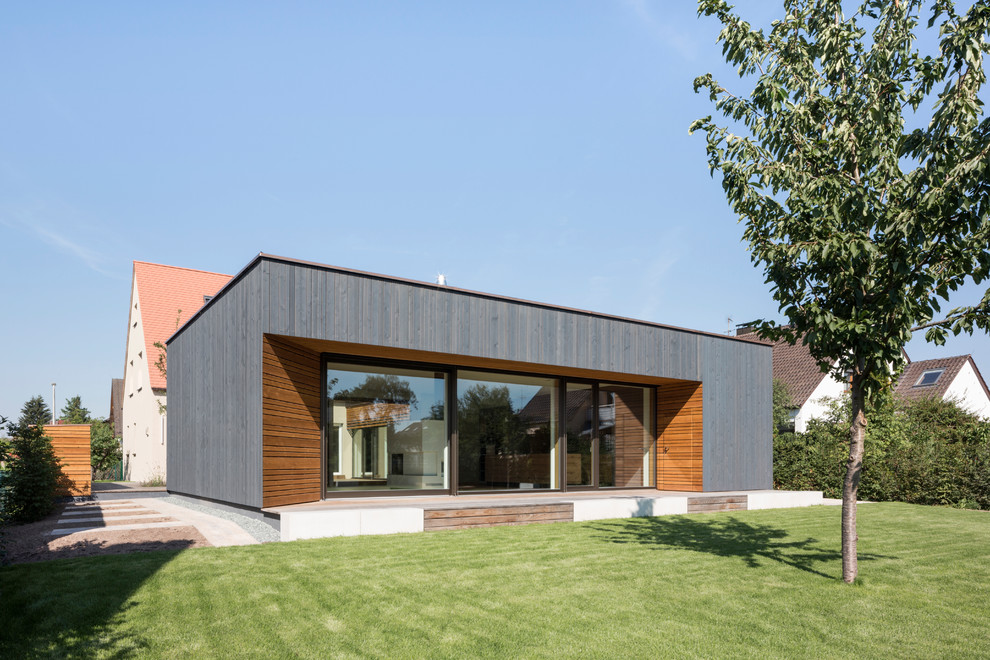 Diseño de fachada de casa multicolor moderna de una planta con revestimiento de madera y tejado plano