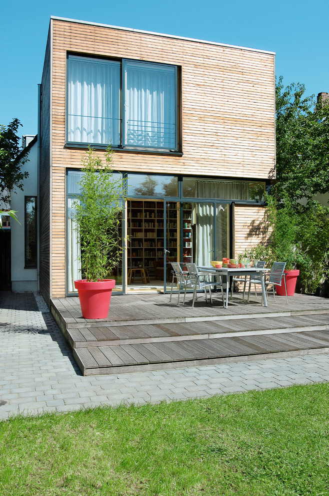 Стильный дизайн: двухэтажный, деревянный, коричневый частный загородный дом среднего размера в современном стиле с плоской крышей - последний тренд