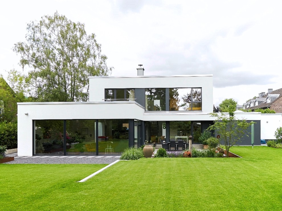 Photo of a large and white contemporary render house exterior in Dusseldorf with a flat roof.
