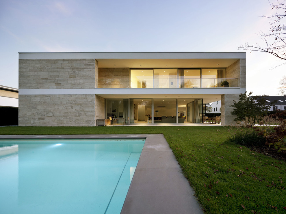 Свежая идея для дизайна: двухэтажный, бежевый, большой дом в современном стиле с плоской крышей и облицовкой из камня - отличное фото интерьера