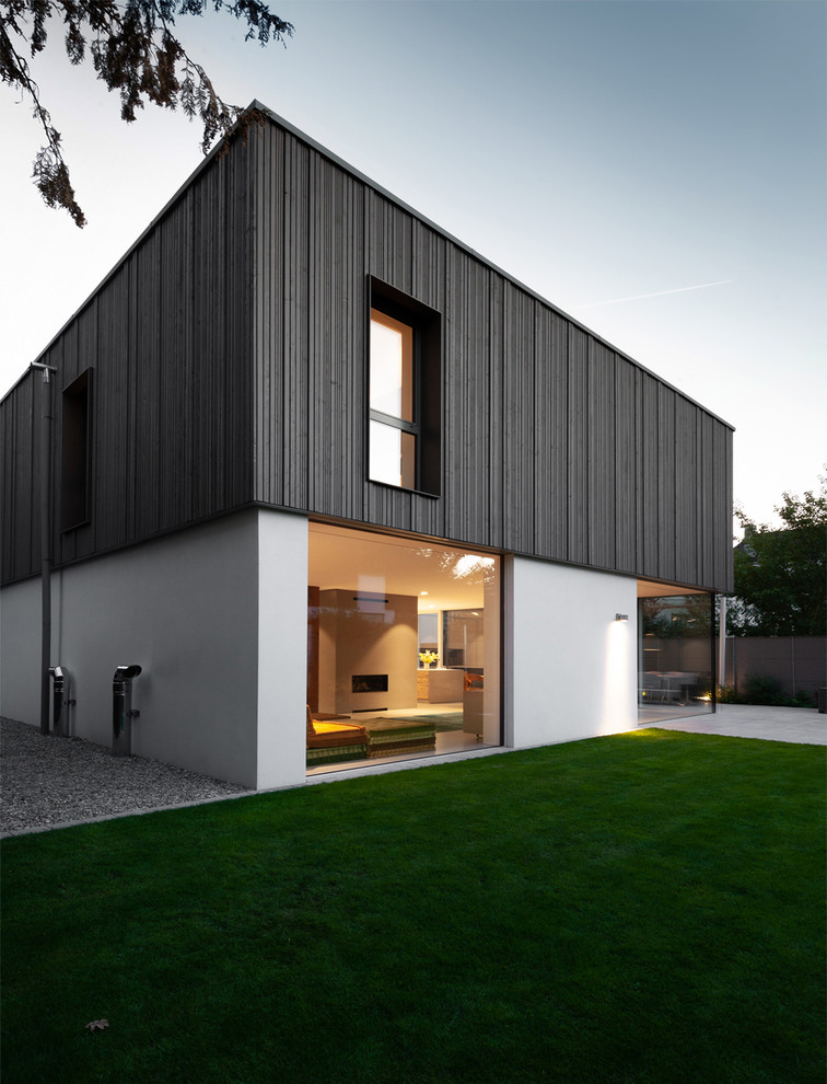 Design ideas for a large and white contemporary two floor detached house in Nuremberg with wood cladding and a flat roof.