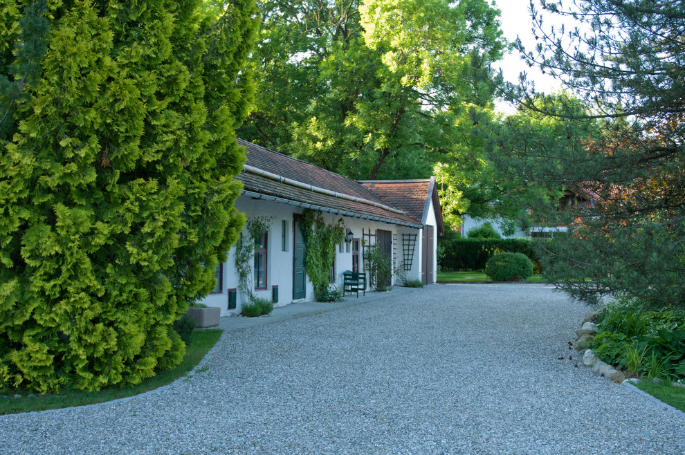 Kleines, Einstöckiges Landhaus Einfamilienhaus mit Putzfassade, weißer Fassadenfarbe, Satteldach und Ziegeldach in München