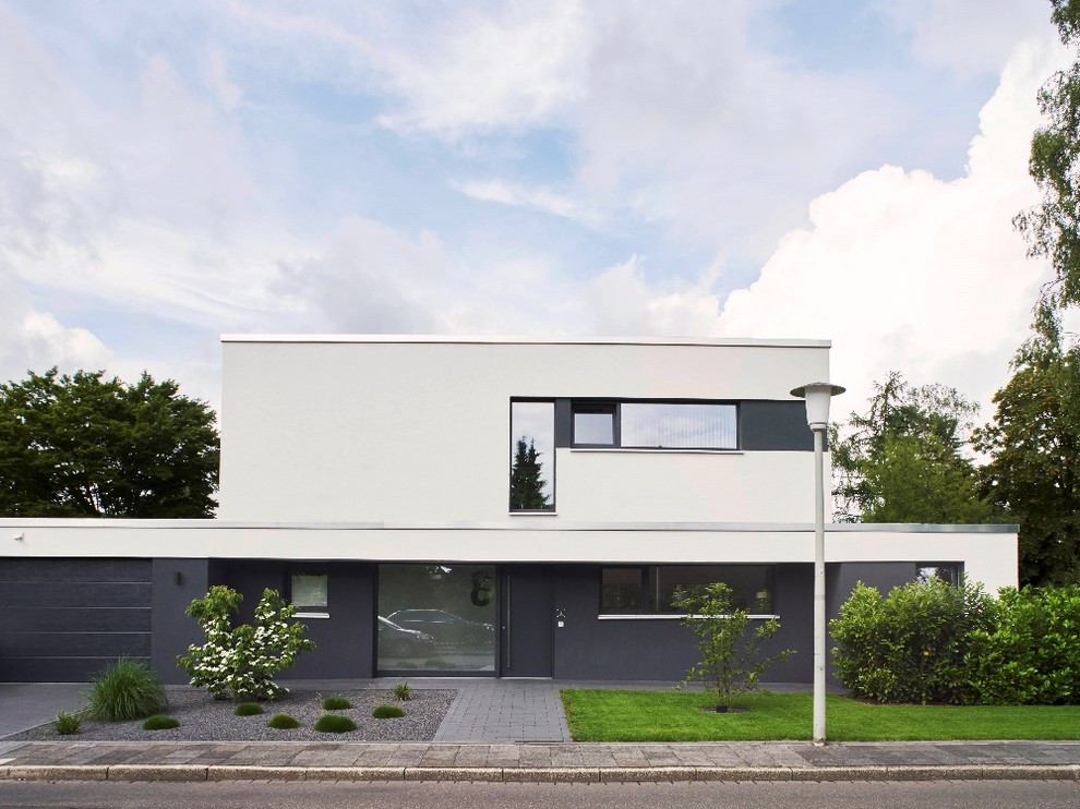 Стильный дизайн: двухэтажный, белый частный загородный дом среднего размера в стиле модернизм с облицовкой из цементной штукатурки и плоской крышей - последний тренд