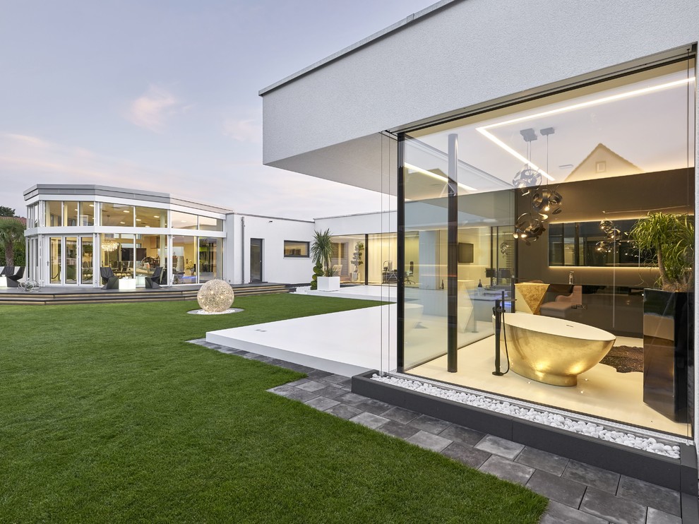 Réalisation d'une façade de maison blanche minimaliste de plain-pied avec un toit plat.