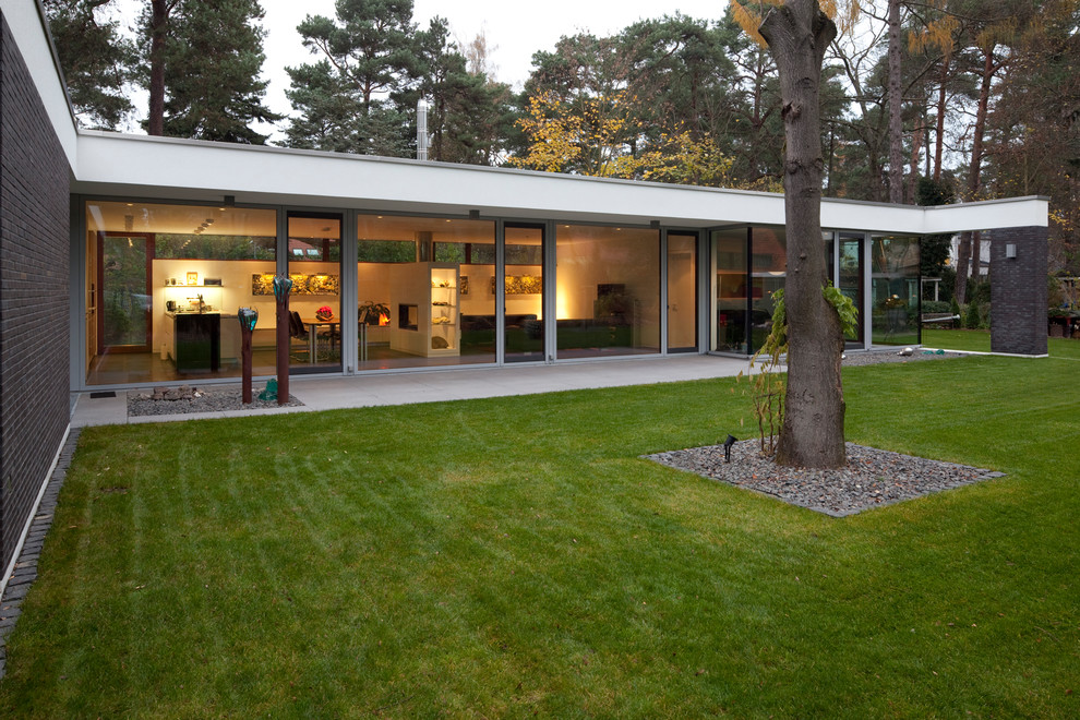 This is an example of a contemporary glass house exterior in Berlin with a flat roof.
