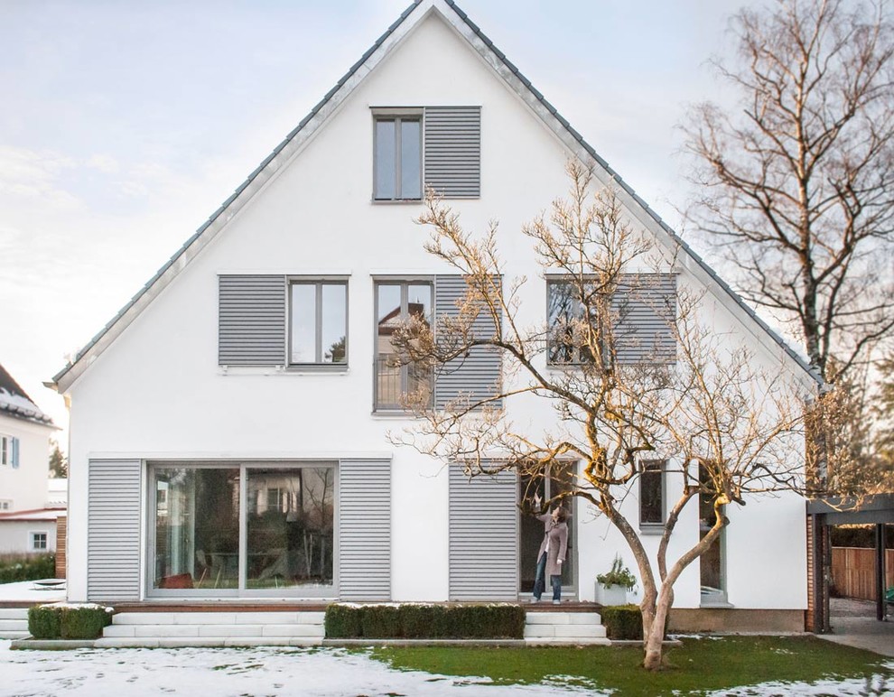 На фото: большой, трехэтажный, белый дом в скандинавском стиле с двускатной крышей