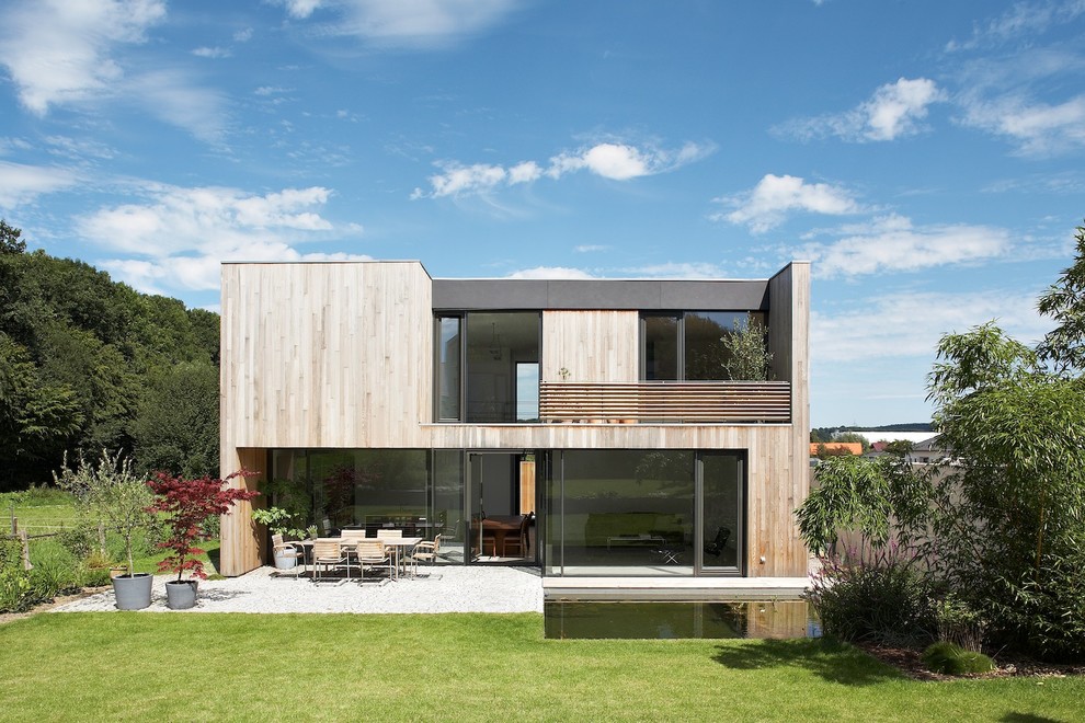 Exemple d'une façade de maison marron moderne en bois de taille moyenne et à un étage avec un toit plat.