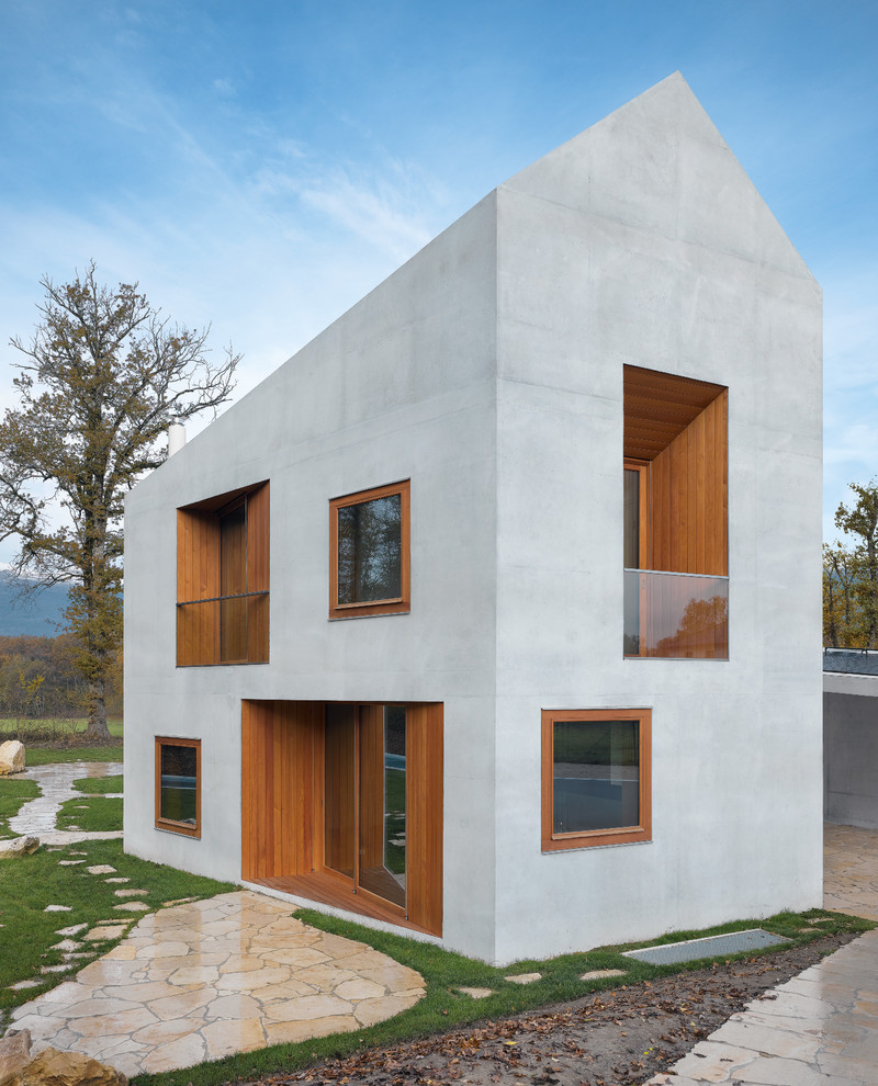 Kleines, Zweistöckiges Modernes Haus mit Betonfassade und grauer Fassadenfarbe in München