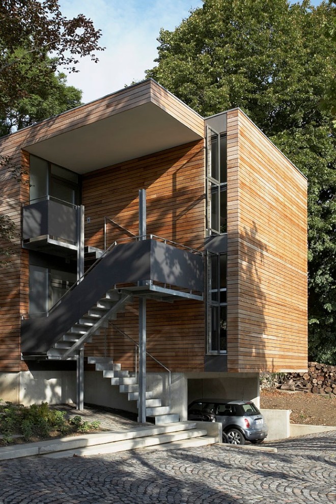 Diseño de fachada marrón contemporánea de tamaño medio de dos plantas con revestimiento de madera y tejado plano